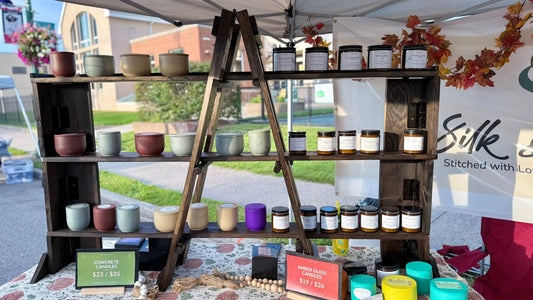 Folding wooden market shelf filled with Silk and Soul concrete and amber glass candles